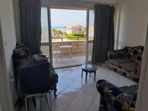 a living room with a tv and a view of the ocean at Paradise villa in Dawwār Ḩalīs