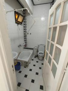 a bathroom with a toilet and a tub and a sink at Paradise villa in Dawwār Ḩalīs
