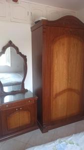 a bedroom with a wooden cabinet and a mirror at Paradise villa in Dawwār Ḩalīs