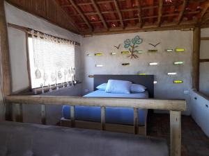 una cama en una habitación con ventana en Chalé Cabana Ecológico, en Bueno Brandão