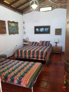 een slaapkamer met 2 bedden en een tafel en een lamp bij Villa Nico hospedaje campestre in Bochalema