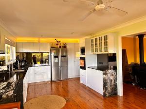 una cucina con armadi bianchi e un ventilatore a soffitto di Mountain View a Woombye