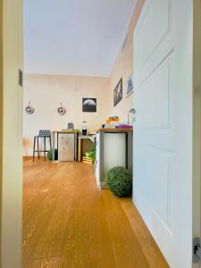Habitación de planta abierta con suelo de madera y puerta blanca en Smart House Rooms Luxury, en Bérgamo