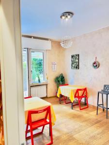 Habitación con 2 mesas y sillas rojas y amarillas. en Smart House Rooms Luxury, en Bérgamo