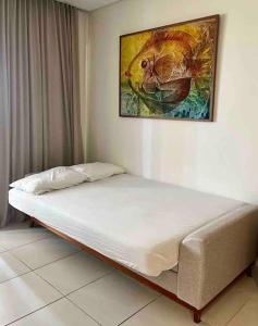 un letto in una stanza con un dipinto sul muro di Flat Eco Resort Praia dos Carneiros @flatcolina a Tamandaré
