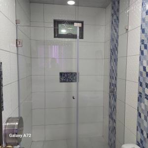 a shower with a glass door in a bathroom at Hostal Boston 2 in Quito