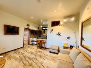 sala de estar con sofá y cocina en Lava Heron Galapagos Apartment, en Puerto Ayora