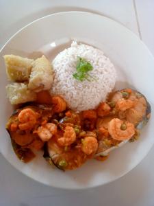 a plate of food with shrimp and rice on a table at Valle del Cardón in Villavieja