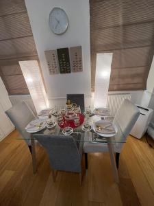 a dining room table with chairs and a clock on the wall at Luxurious 2 bedroom apartment in Central London in London