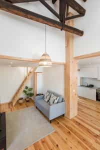 Bento Guest House في بورتو: غرفة معيشة مع أريكة زرقاء وأرضيات خشبية