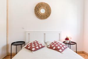 1 cama con 2 almohadas y espejo en la pared en Bento Guest House, en Oporto