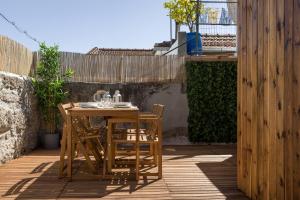 a wooden table and chairs on a patio at Bento Guest House in Porto