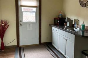 una cocina con fregadero y una puerta con microondas en Parkway Yellowstone Guest House Apartment #5 en Gardiner