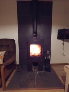 a fireplace in a living room with a fire in it at Madras cottage Orkney Islands in Harray