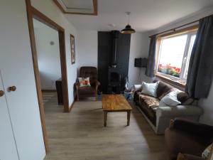 a living room with a couch and a coffee table at Madras cottage Orkney Islands in Harray