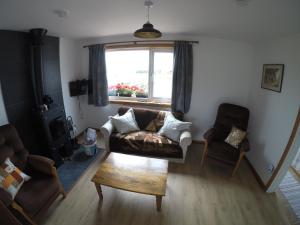 a living room with a couch and a window at Madras cottage Orkney in Harray