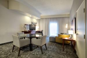 a hotel room with a table and chairs and a living room at Courtyard by Marriott McAllen in McAllen