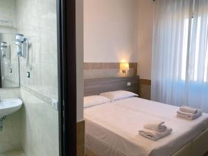 a bedroom with a bed and a sink and a shower at Hotel Alex Square in Rome
