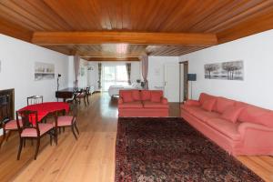 een woonkamer met een rode bank en een tafel bij Yo-House in Costa da Caparica