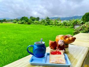 einen Tisch mit einem Teller Essen und einer Tasse Kaffee in der Unterkunft Bua Patumma Resort in Mae Sai