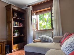 - une chambre avec une fenêtre, un canapé et une étagère dans l'établissement Finca María, à Castropol