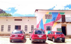 a group of three cars parked in front of a building at Hostal Casona Don Ranulfo in Peñas
