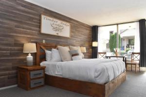 a bedroom with a large bed with a wooden wall at Timber Ridge Lodge - Walking Distance from Downtown Gatlinburg in Gatlinburg