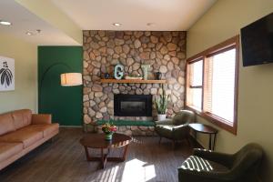 sala de estar con chimenea de piedra y muebles en GreenTree Suites Eagle / Vail Valley, en Eagle