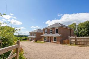 a brick house with a fence on a dirt road at The Orchard - Spacious 5 Bed in Burton upon Trent
