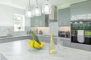 a kitchen with a bottle of wine and bananas on a counter at The Orchard - Spacious 5 Bed in Burton upon Trent