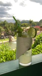 a drink sitting on a window sill with a margarita at Pousada das Hortênsias in São Bonifácio