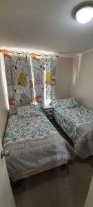 two beds in a small room with at Depto. Condominio La Herradura, Coquimbo in Coquimbo