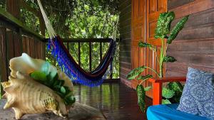 a porch with a hammock and a window at True Nature Jungle House in Bastimentos