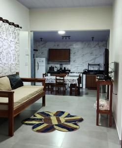 uma sala de estar com um sofá e uma cozinha em Casa Ypê - Vila de São Jorge em Alto Paraíso de Goiás