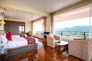 Habitación de hotel con cama y balcón en Sky Garden Resort, en Dhulikhel