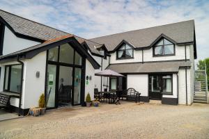 a white house with a black roof at The Briers Country House in Newcastle