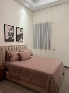 - une chambre avec un grand lit et deux photos sur le mur dans l'établissement Gorgeous 2 Bedrooms Apartment in Bourgogne, à Casablanca