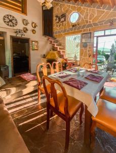 d'une salle à manger avec une table, des chaises et un mur en pierre. dans l'établissement CASA DE PIEDRA EL ZAPATO, à Suesca