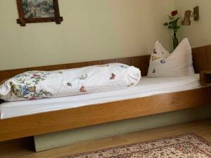 ein Bett mit weißer Bettwäsche und Kissen darauf in der Unterkunft Gasthaus & Pension Zum Fürstengrund in Reichelsheim