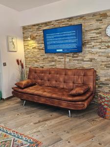 a brown leather couch in a room with a brick wall at Casa Domingos Cales De Mallorca in Calas de Mallorca