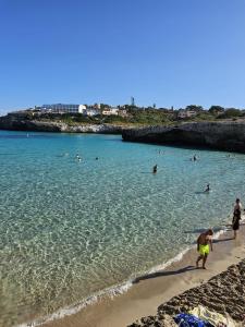 a group of people in the water at a beach at Casa Domingos Cales De Mallorca in Calas de Mallorca