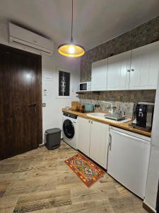 a kitchen with white cabinets and a washer and dryer at Casa Domingos Cales De Mallorca in Calas de Mallorca