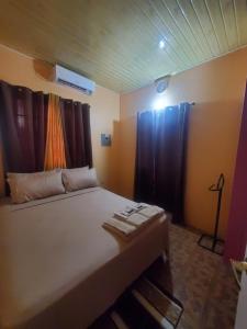 1 dormitorio con 1 cama grande y cortinas negras en K&L Private Room Suites, en Arima