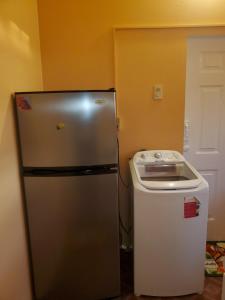 a refrigerator in a kitchen with a sink at K&L Private Room Suites in Arima