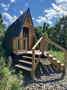 a small cabin with stairs and a black roof at Acres Away in Penn Yan