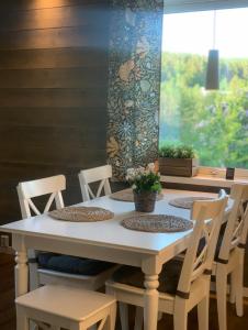 una mesa blanca con sillas y una ventana en Gotell, en Erikslund