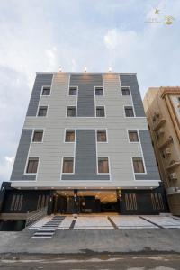 a tall gray building with stairs in front of it at زهرة in Buraymān