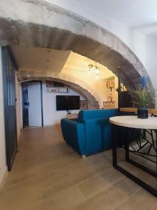 - un salon avec un canapé bleu et une table dans l'établissement Appartement avec jacuzzi, à Saint-Maximin-la-Sainte-Baume