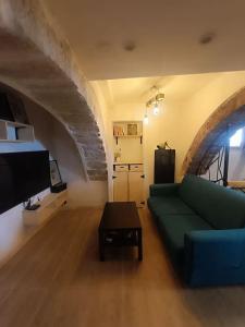 a living room with a blue couch and a tv at Appartement avec jacuzzi in Saint-Maximin-la-Sainte-Baume