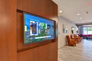 a hospital room with a flat screen tv on a wall at Courtyard by Marriott Long Island Islip/Courthouse Complex in Central Islip